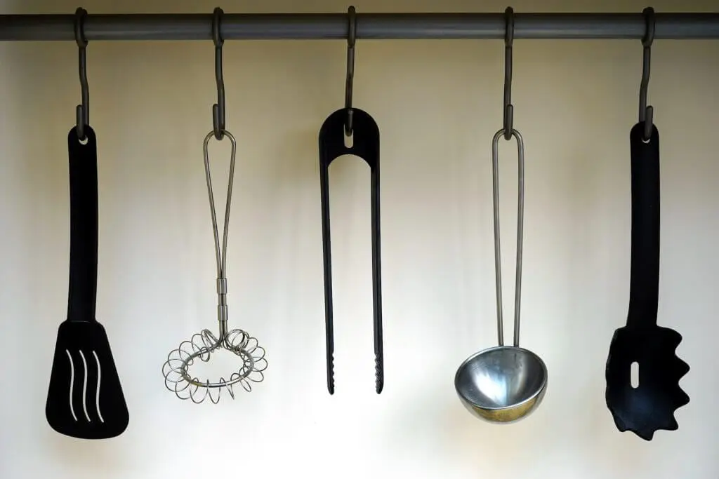 Kitchen utensils hanging on a rack. Declutter your kitchen by organizing tools.