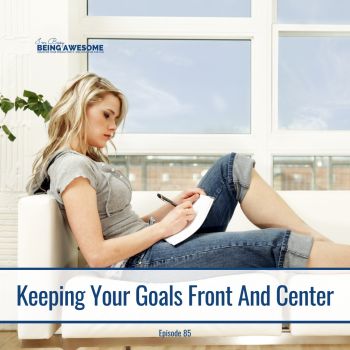 Woman writing goals on paper while relaxing on a couch.