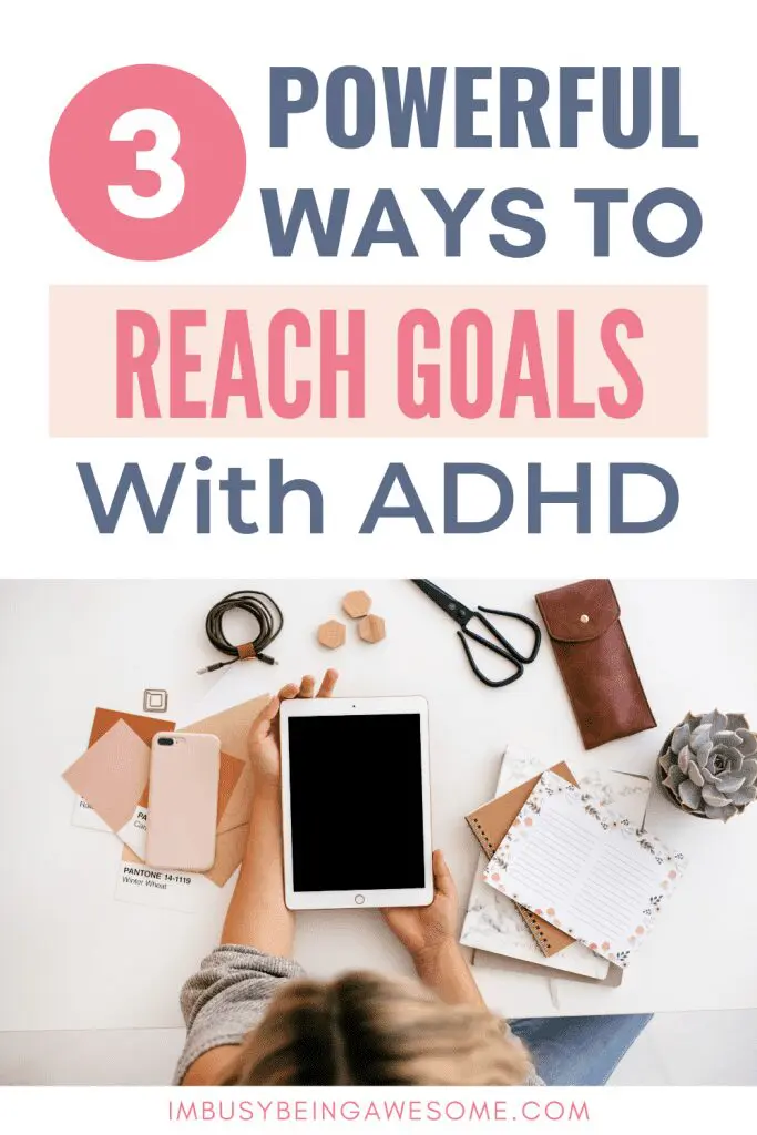 Text: 3 Powerful Ways to Reach Goals with ADHD. Hands holding a tablet surrounded by office supplies.