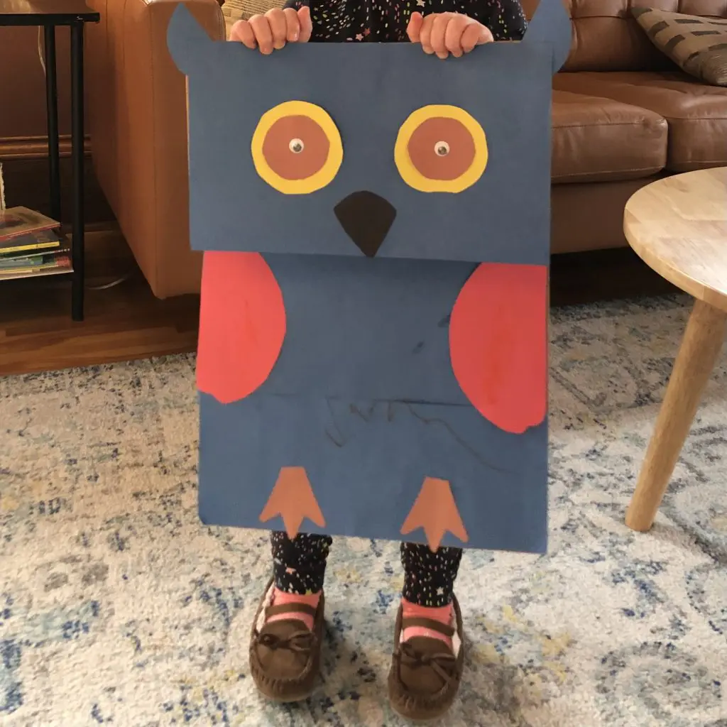 Child holding a homemade owl craft, perfect for resourceful ADHD activities.