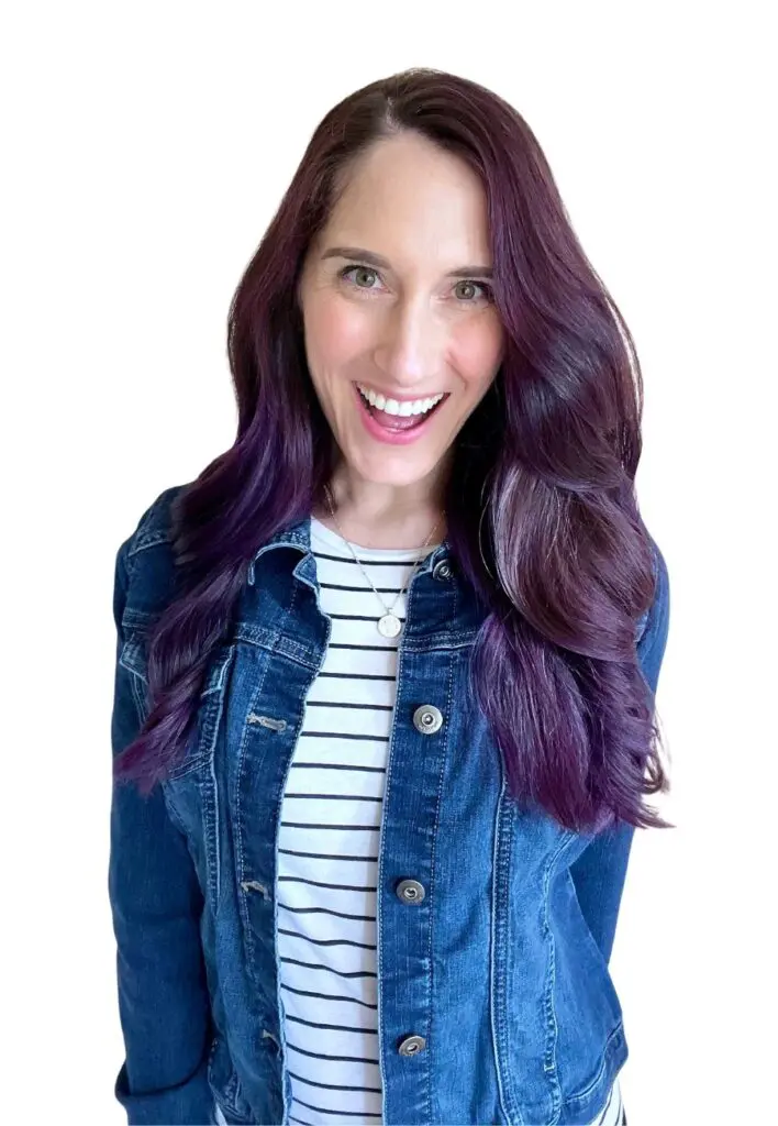 Paula, ADHD coach, smiling with purple hair, wearing a denim jacket.
