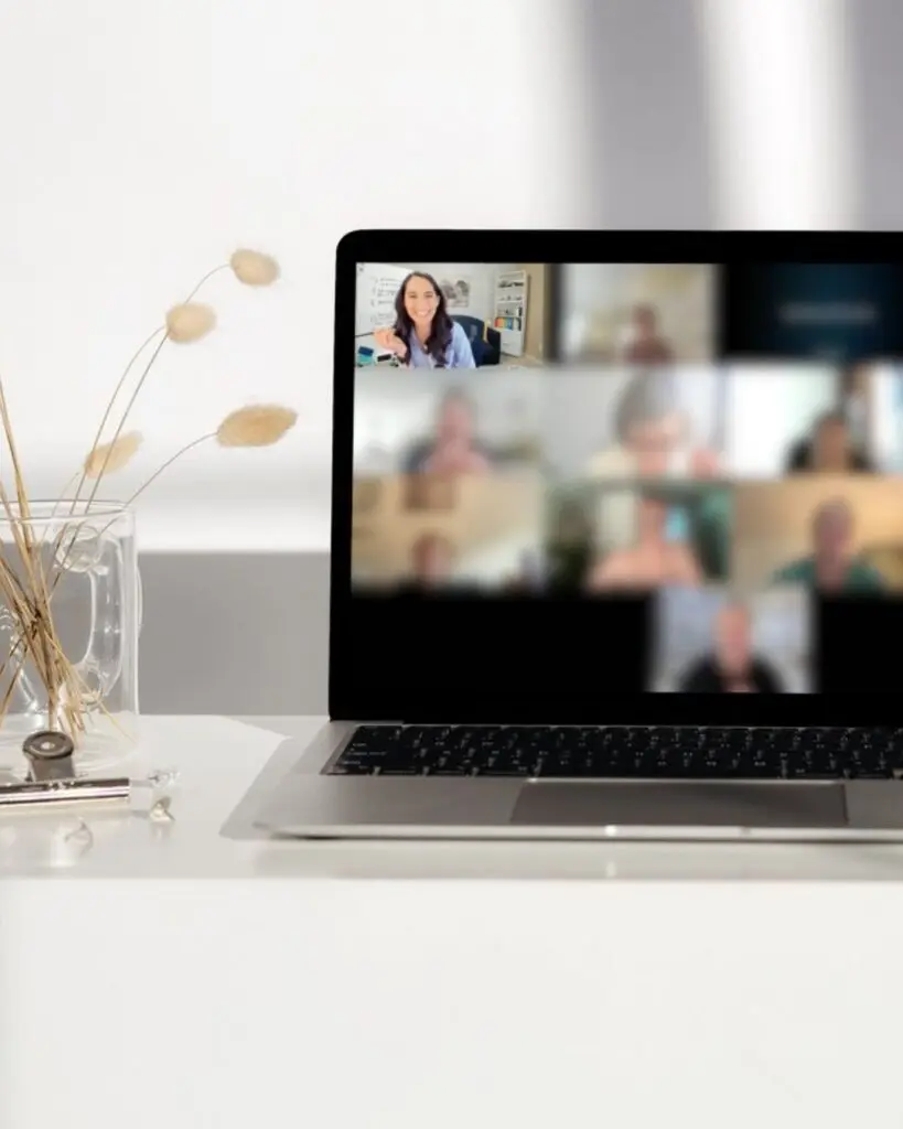 Laptop screen showing a virtual meeting with a woman presenting, part of Overwhelm to Action LIVE.