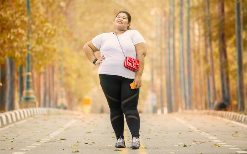 Woman in activewear enjoying a fall fresh start walk in a park.