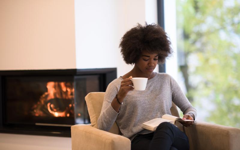 woman reading in front of fire