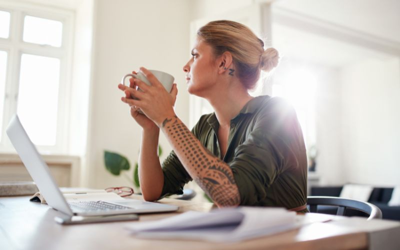 woman sitting at desk looking out window