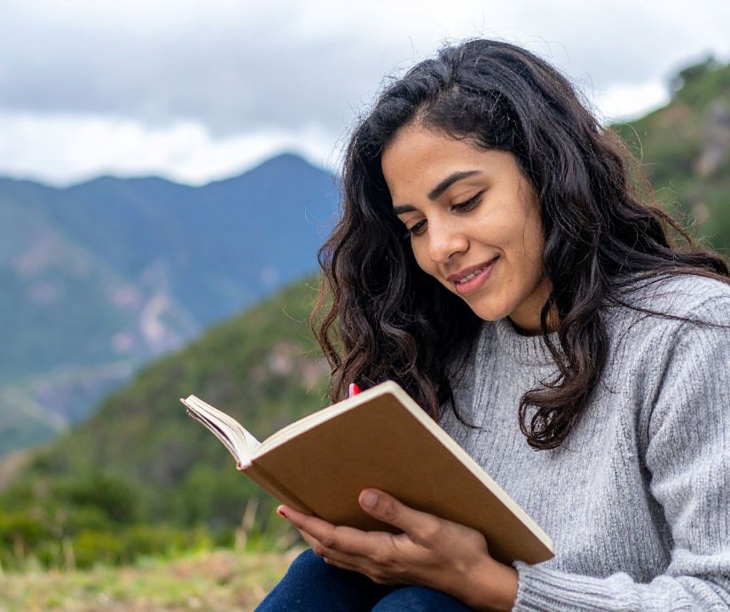 Woman journaling in nature, working on ADHD habit formation.