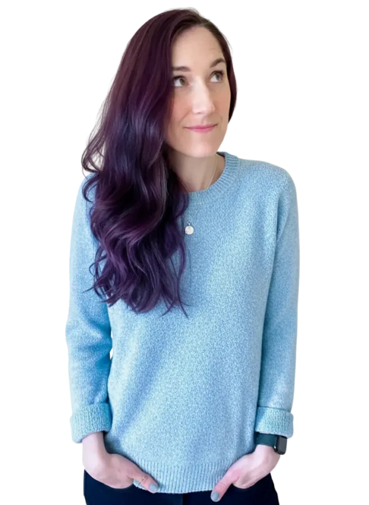 Paula, ADHD coach, looking thoughtfully upwards in a light blue sweater